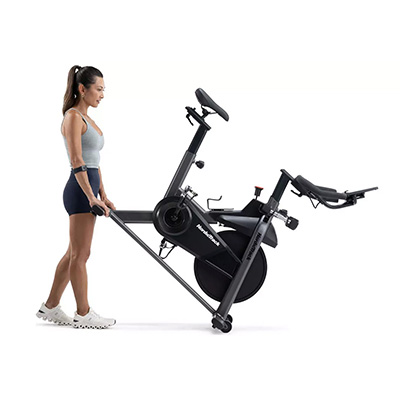 User moving the NordicTrack T Series 9 Bike using transport wheels