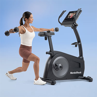User doing strength training next to the NordicTrack G LE Upright Bike 