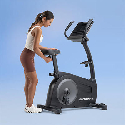User adjusting the seat on the NordicTrack G LE Upright Bike 