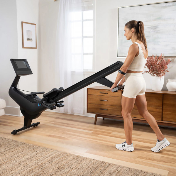 Model moving the NordicTrack RW700 Rowing Machine into position