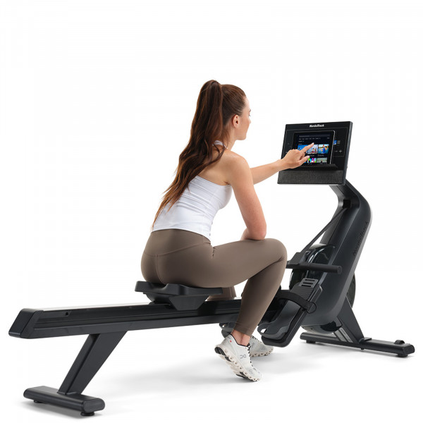 A product image of the NordicTrack RW300 Rower in use with a model using the console.