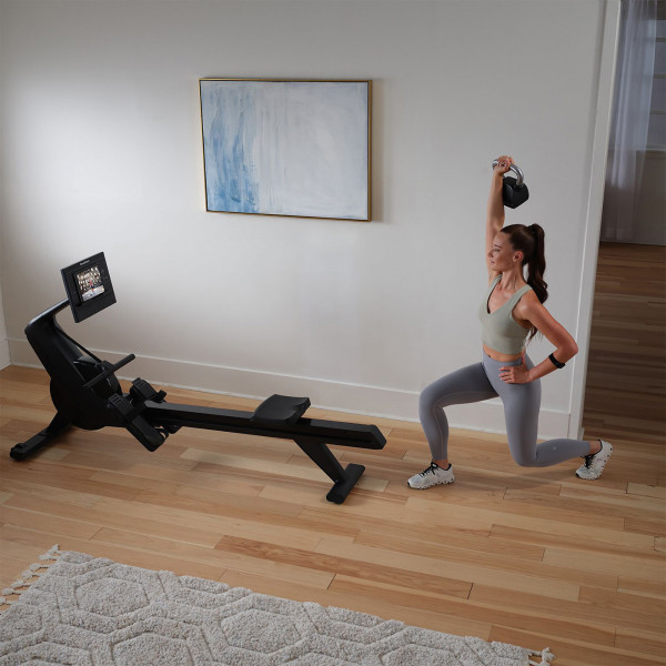 Model doing a strength workout beside the NordicTrack RW300 Rower