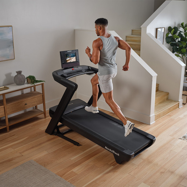 Angled view of a person running on the NordicTrack Commercial LE Treadmill.