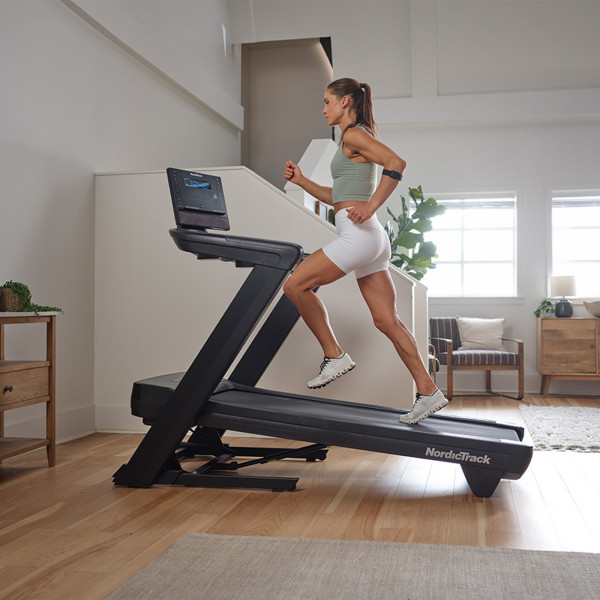 Side view of a person running on an incline on the NordicTrack Commercial LE Treadmill.