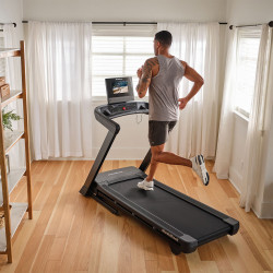 Model running on NordicTrack T Series 10 Treadmill in bright home workout space
