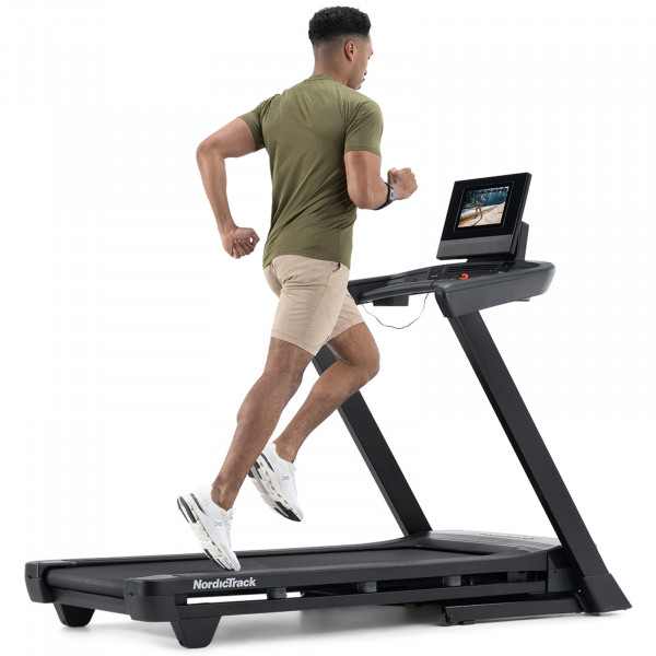 Person running on the NordicTrack T Series 10 Treadmill with iFIT workout displayed.

