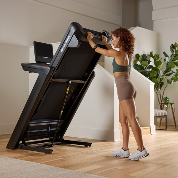 Person folding up the NordicTrack Commercial 1750 Treadmill.