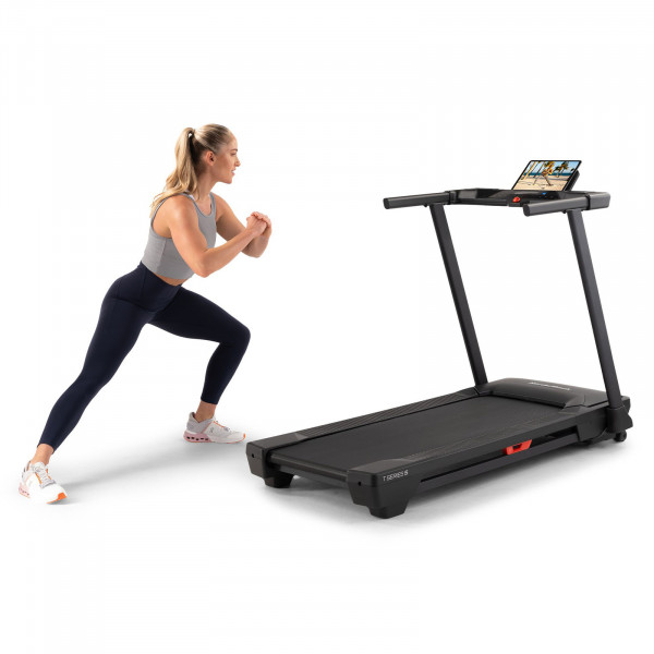 Model doing lunges next to the NordicTrack T Series 5 Treadmill