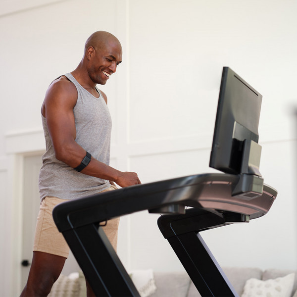Person setting up the NordicTrack Commercial 2450 Treadmill console.