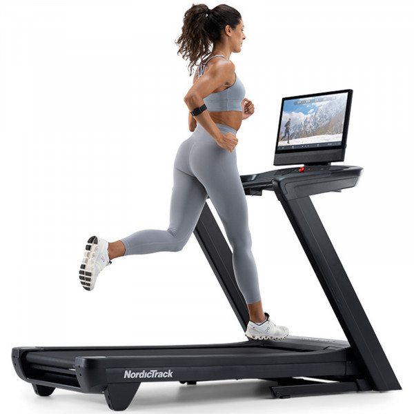 Side view of a person running on the NordicTrack Commercial 2450 Treadmil.