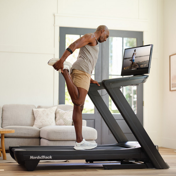 Person stretching on the NordicTrack Commercial 2450 Treadmill.