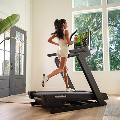 Angled view of a person running on the NordicTrack Commercial 2450 Treadmil.