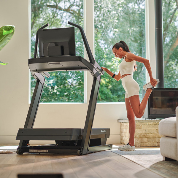 Person stretching on the NordicTrack X24 Treadmill.