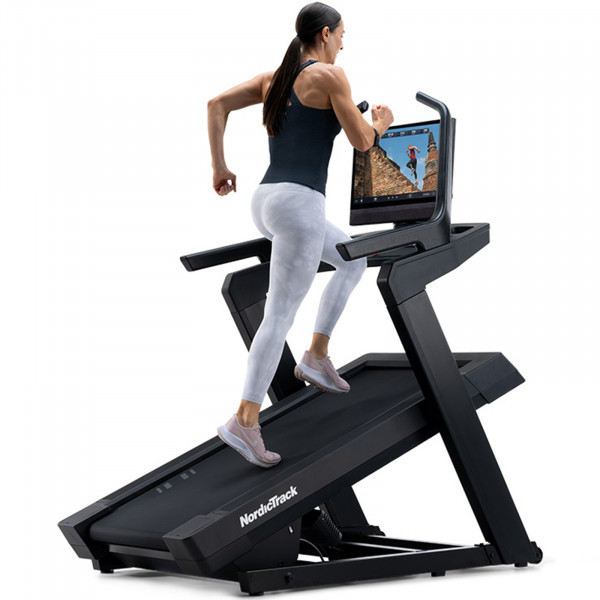 Front right view of a person running on the NordicTrack Commercial 2450 Treadmil at an incline.