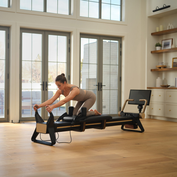 Model doing kneeling carriage press on the NordicTrack Ultra 1 Reformer