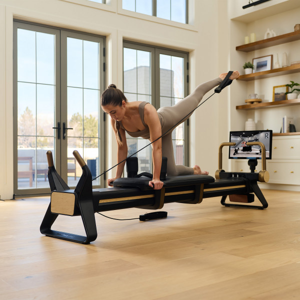 Model performing leg extension on the NordicTrack Ultra 1 Reformer