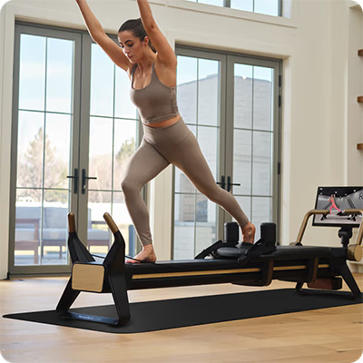 Model doing standing leg extension on the NordicTrack Ultra 1 Reformer  
