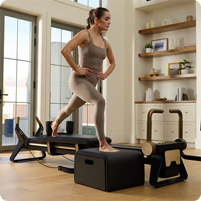 Model doing step-up exercise on the NordicTrack Ultra 1 Reformer