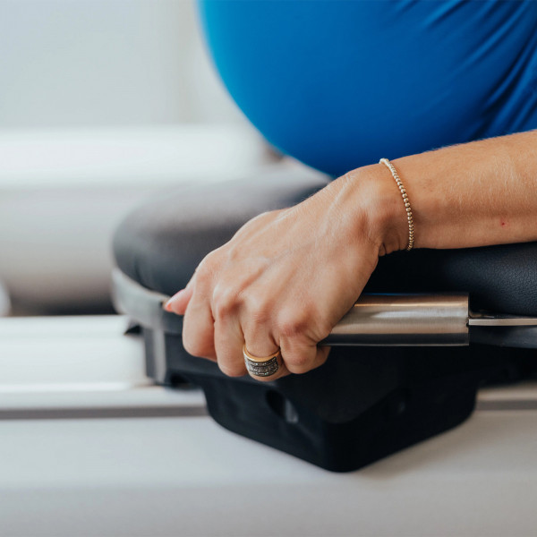 Close-up of hand holding the side stabiliser bar on the NordicTrack Ultra 1 Reform RX-S