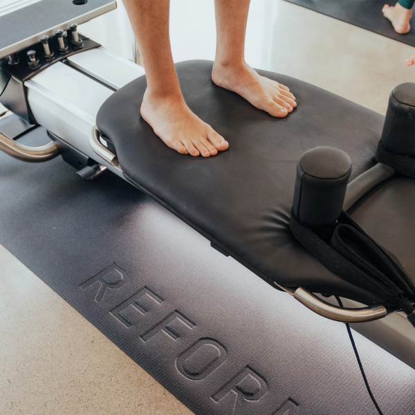 Barefoot stance on the padded carriage platform during standing exercise on the NordicTrack Ultra 1 Reform RX-S