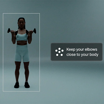 An image of a model performing bicep curls. The model is surrounded by an interface box and an on-screen caption reads: "Keep your elbows close to your body."