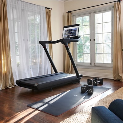 Peloton Original Series Tread set up in a bright living room with accessories