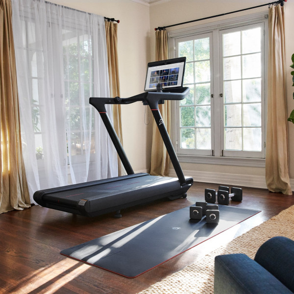 Peloton Original Series Tread set up in a bright living room with accessories