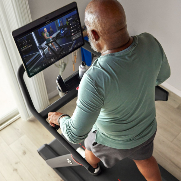 Top view of a person interacting with a guided class on the Peloton Original Series Tread screen
