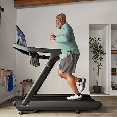 Person jogging on the Peloton Original Series Tread in a home workout space