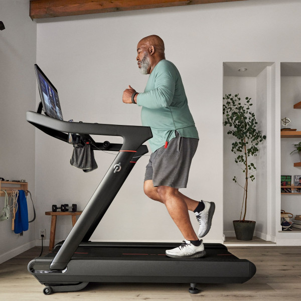 Person jogging on the Peloton Original Series Tread in a home workout space