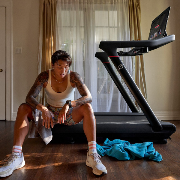 Person resting on the Peloton Original Series Tread after a session