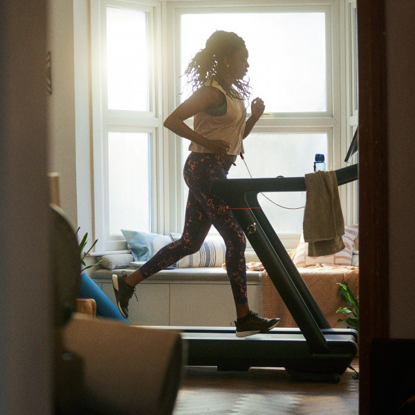 Person running on the Peloton Original Series Tread in a bright living room