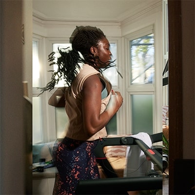 Person running on the Peloton Original Series Tread in a windowed room