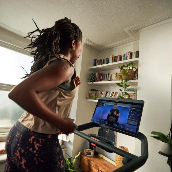 Close-up side view of a person using the Peloton Original Series Tread screen
