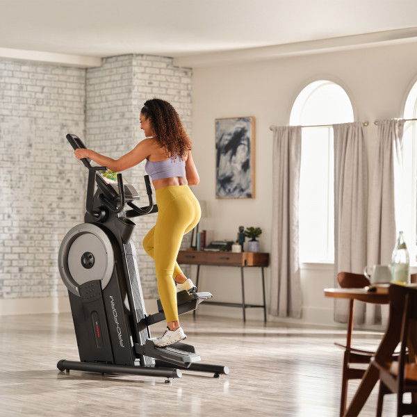 Side view of user mid-stride on the ProForm Trainer HL Elliptical Machine & Stepper