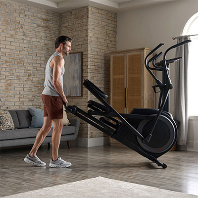 Model moving the ProForm Carbon EL Elliptical around the home using transport wheels 