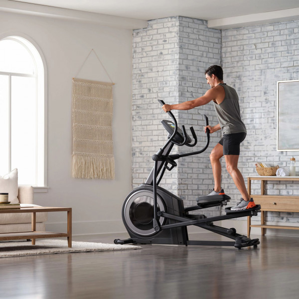 Person training on the ProForm Carbon E7 Elliptical in living room