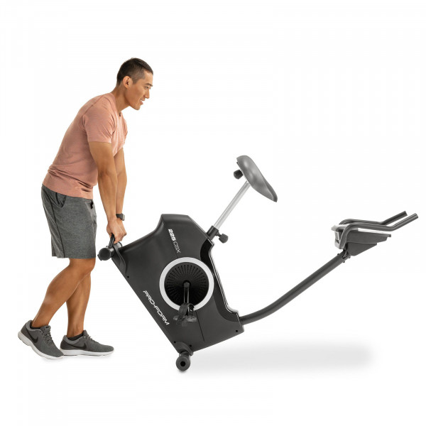 Product image of the ProForm 225 CSX Upright Exercise Bike showing the bike being transported by a model