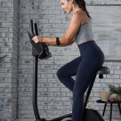 Profile view of a model riding the ProForm 225 CSX Upright Exercise Bike 