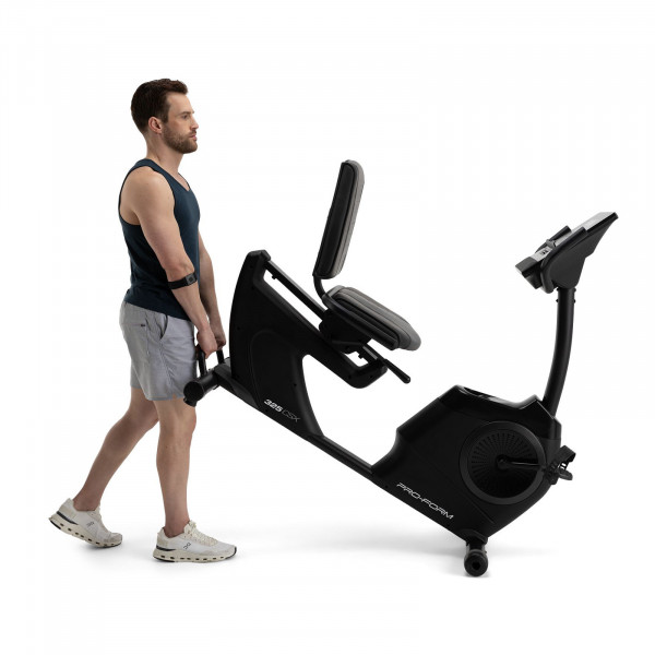 Side view of a user moving the ProForm 325 CSX Recumbent Bike using transport wheels