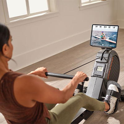Image of a model using the ProForm 550R Rower. The model is using the iFIT app on their tablet. The tablet is not included with the 550R