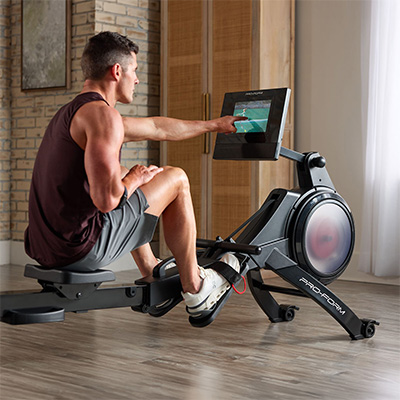 Model selecting a workout on the ProForm Carbon Pro10 Rower touchscreen 