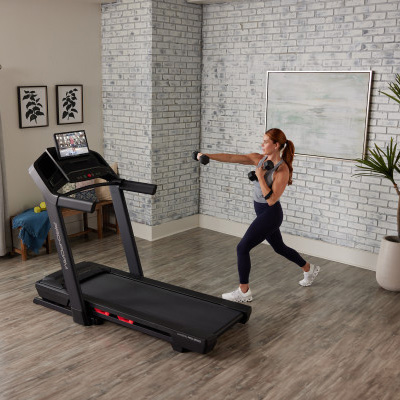 Image of a model using dumbbells using the ProForm Carbon Pro 9000 Treadmill to watch an exercise class.