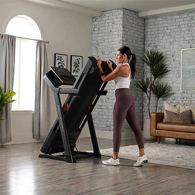 Model folding the ProForm Carbon TLS Treadmill for storage 