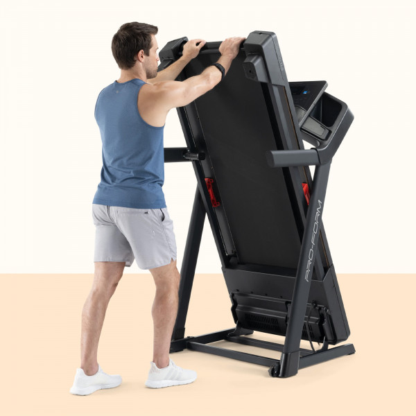 Model lifting the deck on the ProForm Carbon TLS Treadmill for storage