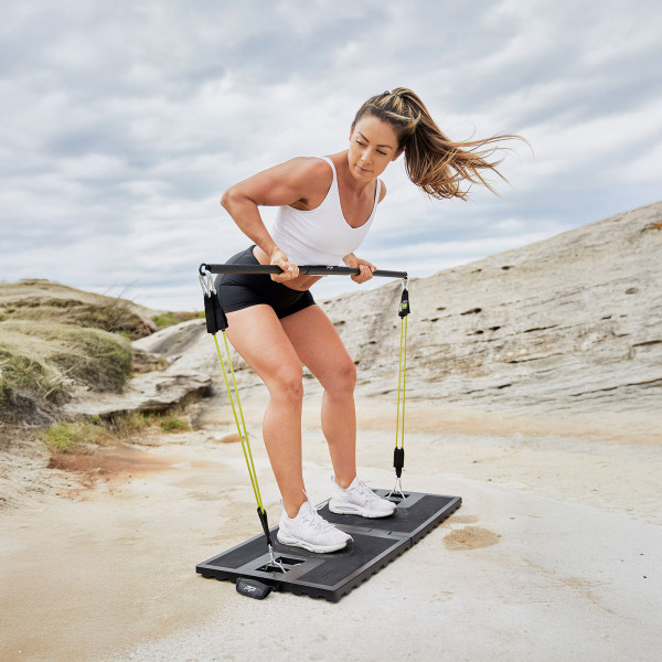 User doing bent-over row outdoors