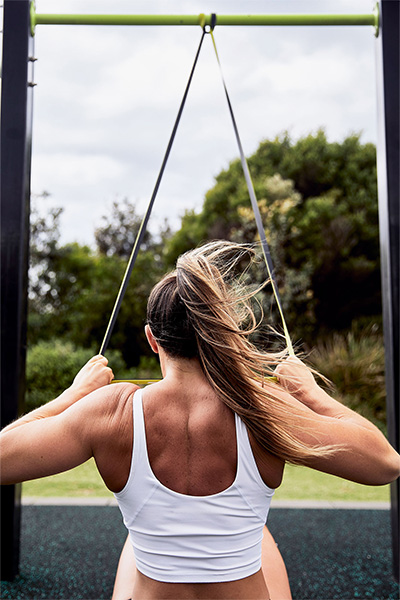 User doing outdoor pull-up assistance exercise with yellow (light resistance) SuperBand