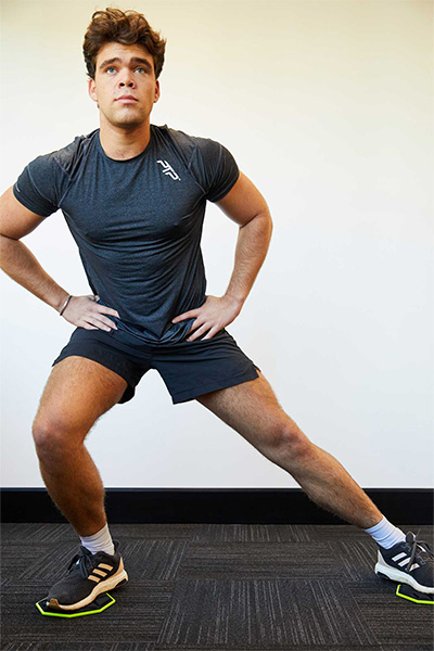 Model using the PTP Core Sliders for a lateral lunge exercise.