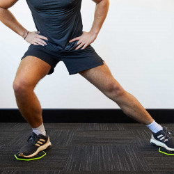 Model using the PTP Core Sliders for a lateral lunge exercise.
