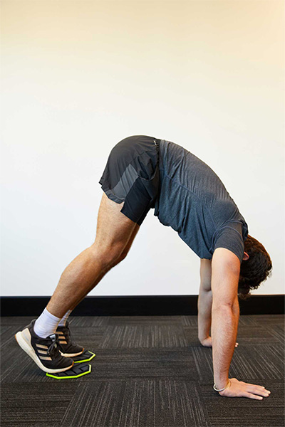 Model using the PTP Core Sliders for a pike exercise in a plank position.